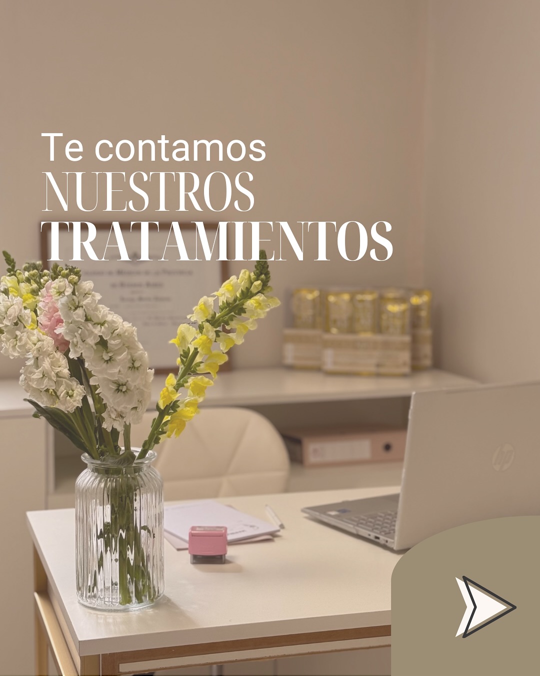 El escritorio de consulta: un florero con flores blancas, rosas y amarillas, una notebook y, al fondo, un diploma en la pared